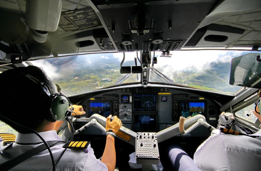 Two pilots are flying a plane in the sky.
